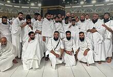 A group of Indian pilgrims with sensory disabilities dressed in ihram pose for a photo after completing Umrah at the Grand Mosque in Makkah.
