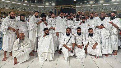 A group of Indian pilgrims with sensory disabilities dressed in ihram pose for a photo after completing Umrah at the Grand Mosque in Makkah.