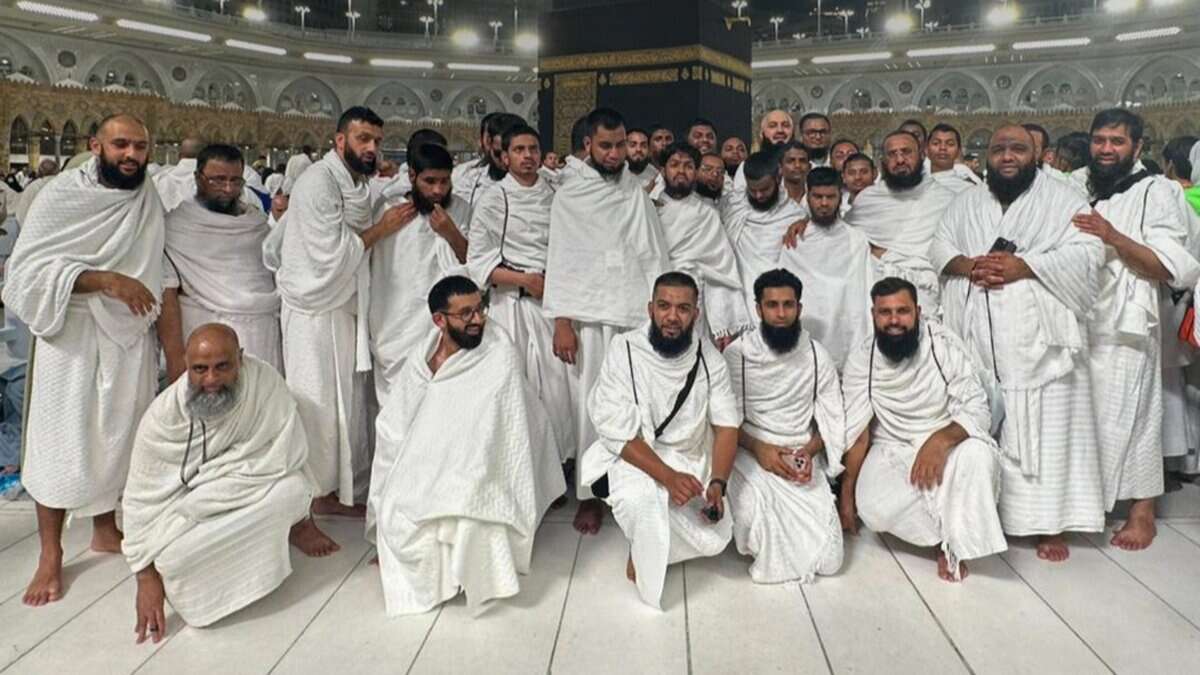 A group of Indian pilgrims with sensory disabilities dressed in ihram pose for a photo after completing Umrah at the Grand Mosque in Makkah.