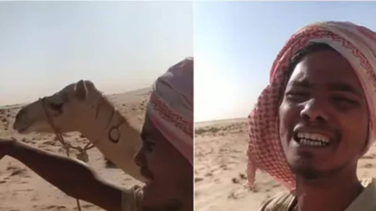 Indian man appears in a desert with a camel in the background while recording a video plea for help.