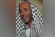 Italian activist wearing a black-and-white Palestinian keffiyeh speaks after embracing Islam.