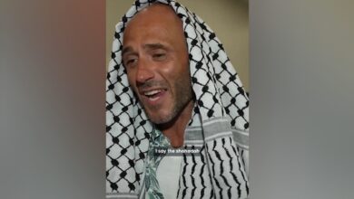 Italian activist wearing a black-and-white Palestinian keffiyeh speaks after embracing Islam.