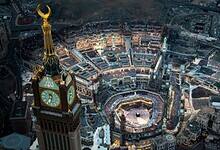 Aerial view of the Grand Mosque in Makkah, Saudi Arabia, filled with pilgrims around the Kaaba during prayer.