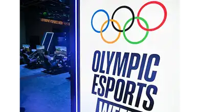 Olympic Esports Week logo displayed beside gaming stations at an event.