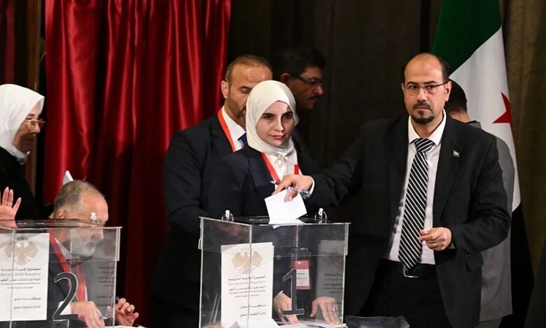 A member of Syria’s local committees casts his vote during the country’s interim parliament selection process in Damascus, October 5, 2025.