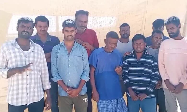 A group of stranded Telangana migrant workers in Jordan standing together under the sun, appealing for help to return home.