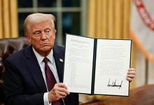 US President Donald Trump displays a signed executive order at the White House.