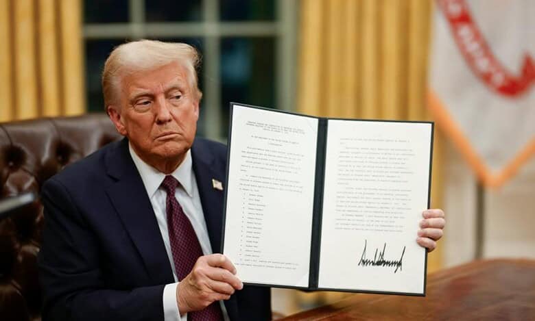 US President Donald Trump displays a signed executive order at the White House.