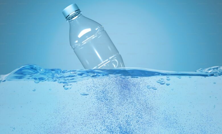 Plastic bottle half-submerged in water with bubbles rising, symbolising water pollution.