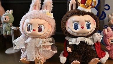 Two Labubu collectible dolls dressed in furry costumes with bunny ears displayed on a table.