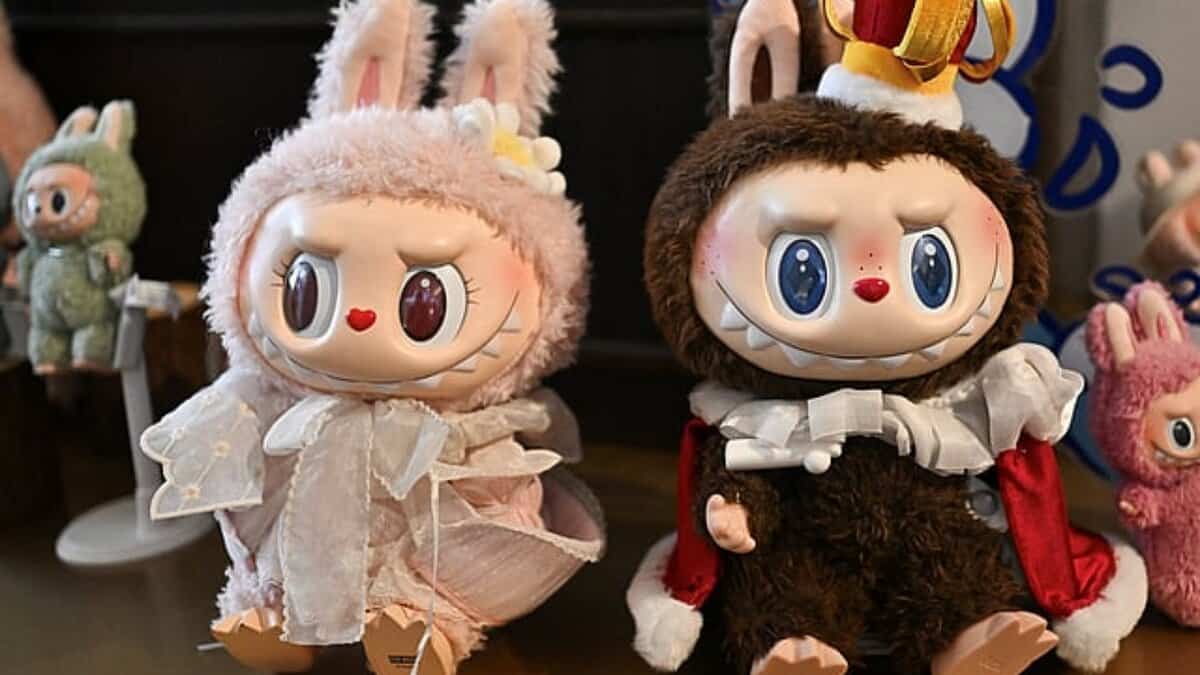 Two Labubu collectible dolls dressed in furry costumes with bunny ears displayed on a table.