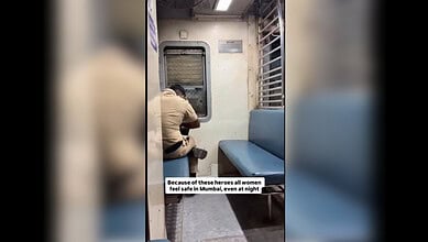 Mumbai policeman keeps watch over a lone woman on a local train.