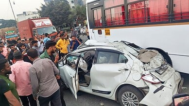 People stand near mangled remains of a car after an accident on the Mumbai-Bengaluru Highway, in Pune- PTI