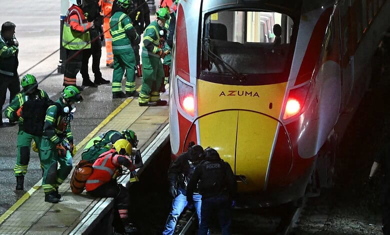_Police search the track beneath a train after stabbing in Huntingdon, UK.