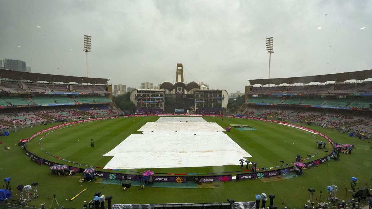 Groundsmen cover the field amid rain at the DY Patil Stadium ahead of the ICC Women's World Cup 2025 cricket final match between India Women and South Africa Women, in Navi Mumbai, Sunday, Nov. 2, 2025. (PTI Photo/Kunal Patil)