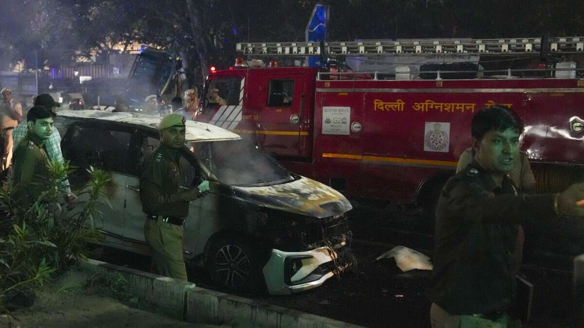 Police personnel at the spot after a blast occurred in a parked car near Red Fort, leaving multiple vehicles in flames in New Delhi on Monday. Eight people have died and atleast 24 injured. (PTI Photo/Salman Ali)