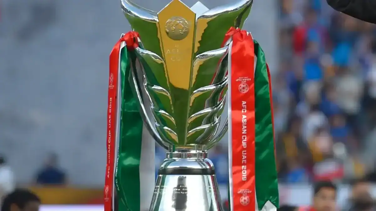 A close-up view of the AFC Asian Cup trophy with red and green ribbons from the UAE 2019 tournament.