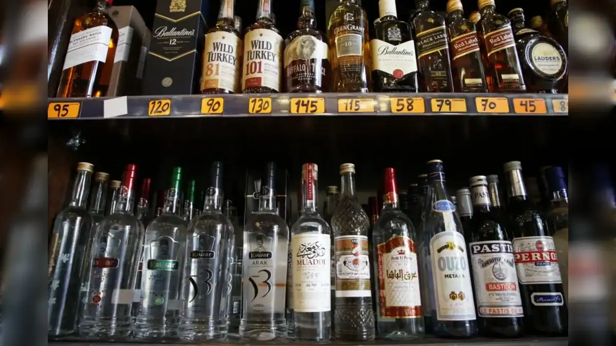 Shelves stocked with various alcoholic drinks, including Arabic arak, whiskies and spirits, arranged in a liquor store.