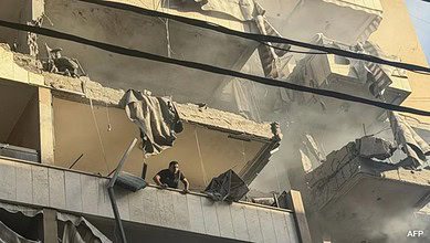 A damaged Beirut building after an Israeli airstrike, with a man standing on a shattered balcony.