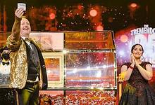 Big Ticket Abu Dhabi hosts celebrate on stage as they announce the Dh 25 million jackpot winner during a live draw, with confetti and bright lights in the background.