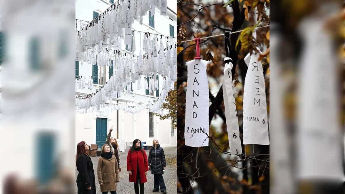 Left: Rows of white fabric strips bearing the handwritten names and ages of Palestinian children hang across a courtyard in Brescia, Italy, as several women look up at the installation. Right: Close-up of two white cloth ribbons tied to a branch, showing children’s names “SANAD” and “MEER” with their ages written below.