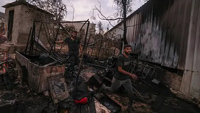 Palestinian men walk through the charred remains of a burned house after a settler attack in Beit Lid village, West Bank.