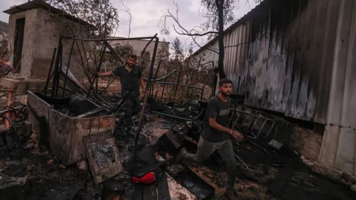 Palestinian men walk through the charred remains of a burned house after a settler attack in Beit Lid village, West Bank.