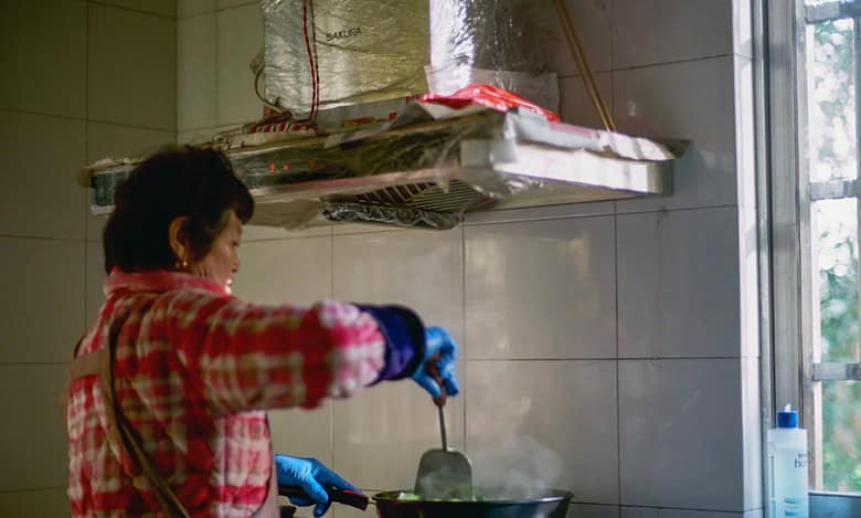 A representative image of a domestic worker cooking in a kitchen.