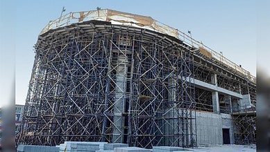 A partially built vertiport structure surrounded by dense scaffolding at a construction site in Dubai.