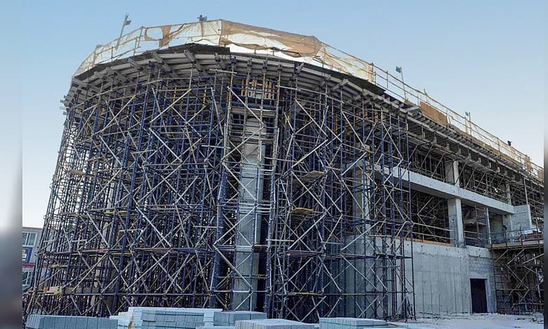 A partially built vertiport structure surrounded by dense scaffolding at a construction site in Dubai.