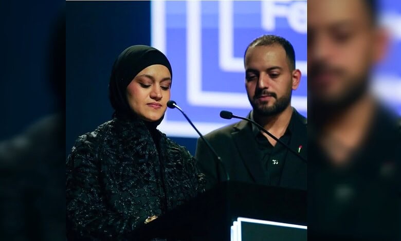 Hind Rajab’s mother speaks emotionally at a podium beside a man during a film festival event.