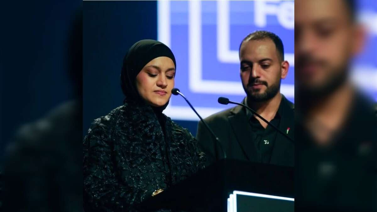 Hind Rajab’s mother speaks emotionally at a podium beside a man during a film festival event.