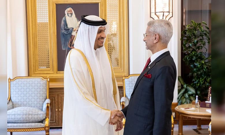 A senior Indian official shakes hands with a Qatari leader during a meeting in an ornate room.
