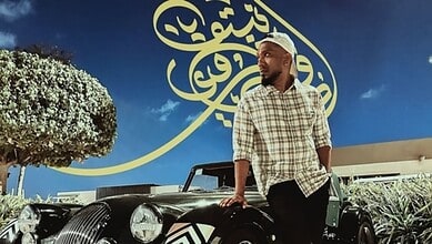 Advin Roy Netto standing beside a vintage car in Abu Dhabi.