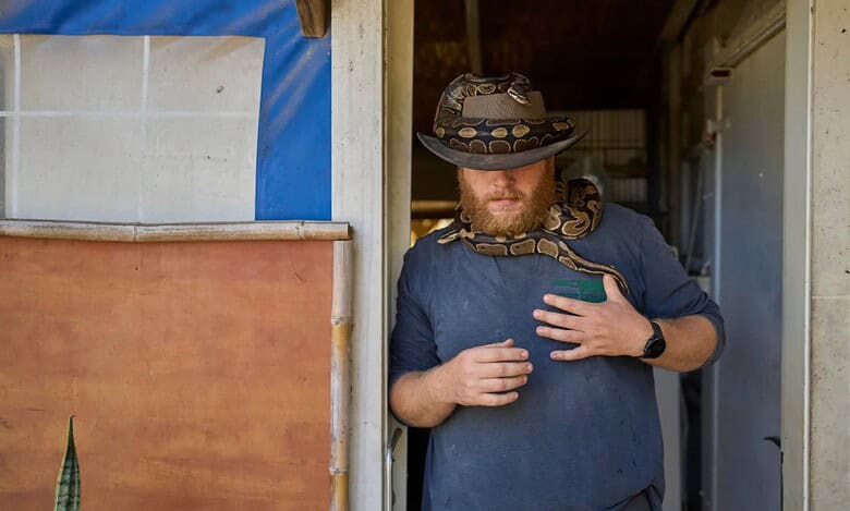 Israeli soldier takes part in animal therapy with a snake at the Back2Life farm in central Israel.
