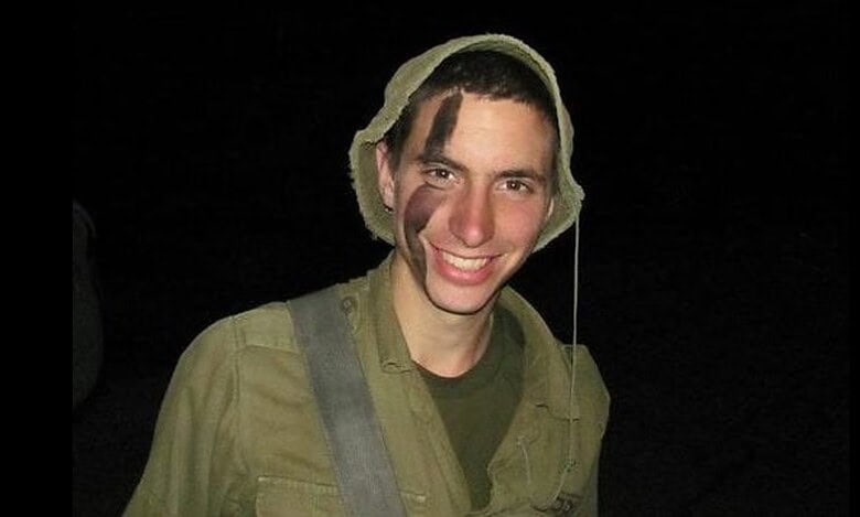 Israeli soldier Hadar Goldin smiling in uniform at night.