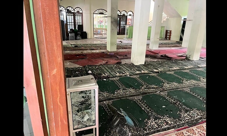 Interior of a mosque in Jakarta showing shattered glass, debris, and damaged prayer mats after explosions during Friday prayers.