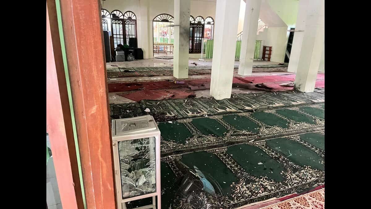 Interior of a mosque in Jakarta showing shattered glass, debris, and damaged prayer mats after explosions during Friday prayers.