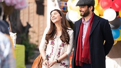 Mahira Khan and Fawad Khan share a warm moment outdoors, smiling during a scene from the film Neelofar, with colourful balloons in the background.