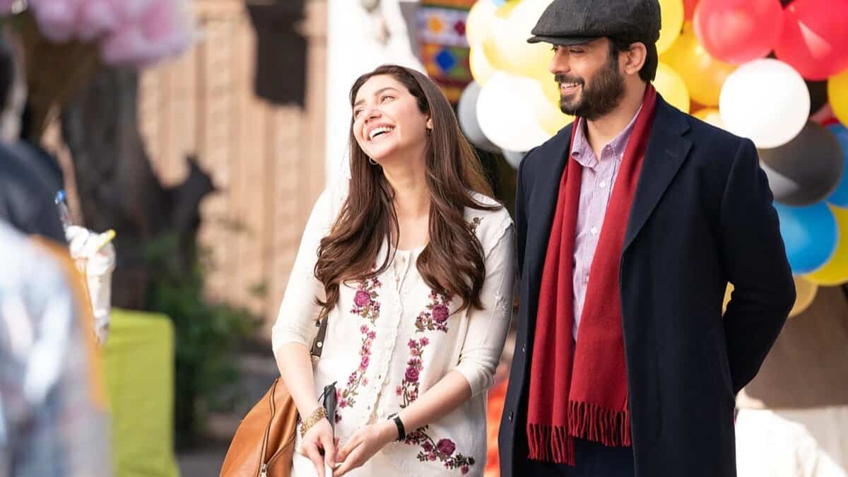 Mahira Khan and Fawad Khan share a warm moment outdoors, smiling during a scene from the film Neelofar, with colourful balloons in the background.