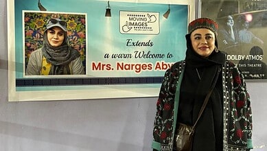 Iranian filmmaker Narges Abyar stands beside a welcome banner at the Hyderabad film festival.
