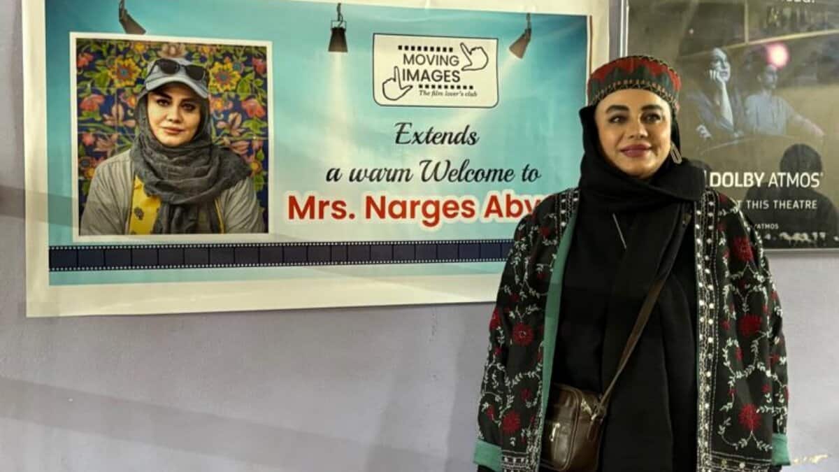 Iranian filmmaker Narges Abyar stands beside a welcome banner at the Hyderabad film festival.