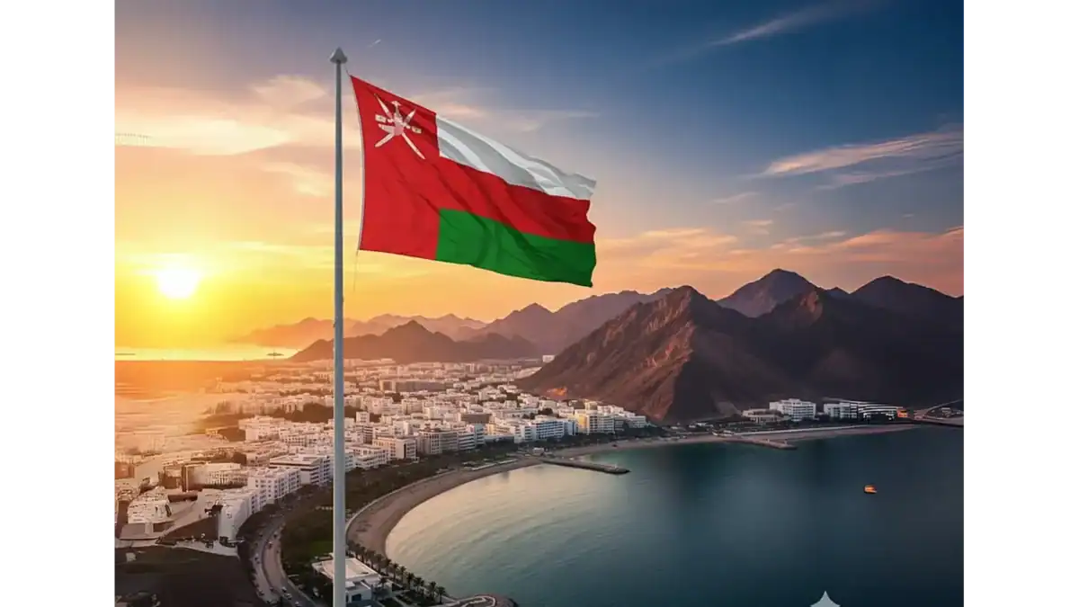Omani flag waving over Muscat city at sunset with mountains in the background.