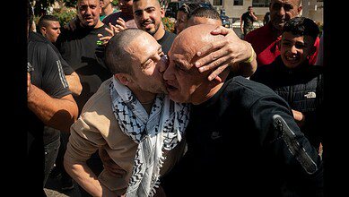 A released Palestinian prisoner kisses a relative as families gather in a subdued celebration in the West Bank.