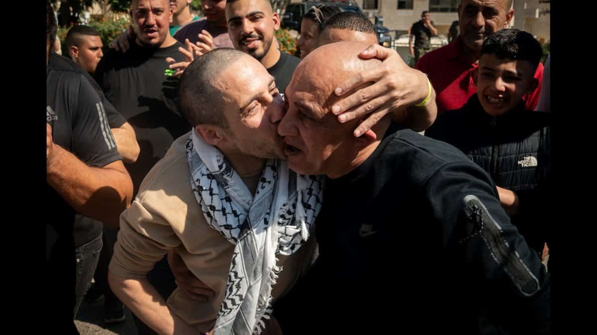 A released Palestinian prisoner kisses a relative as families gather in a subdued celebration in the West Bank.