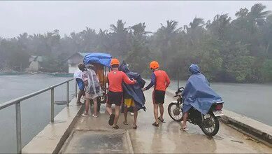 Philippine Coast Guard personnel assist residents during evacuations in heavy rain in Quezon province ahead of Super Typhoon Fung-wong.
