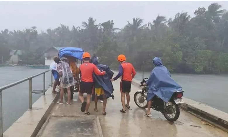 Philippine Coast Guard personnel assist residents during evacuations in heavy rain in Quezon province ahead of Super Typhoon Fung-wong.
