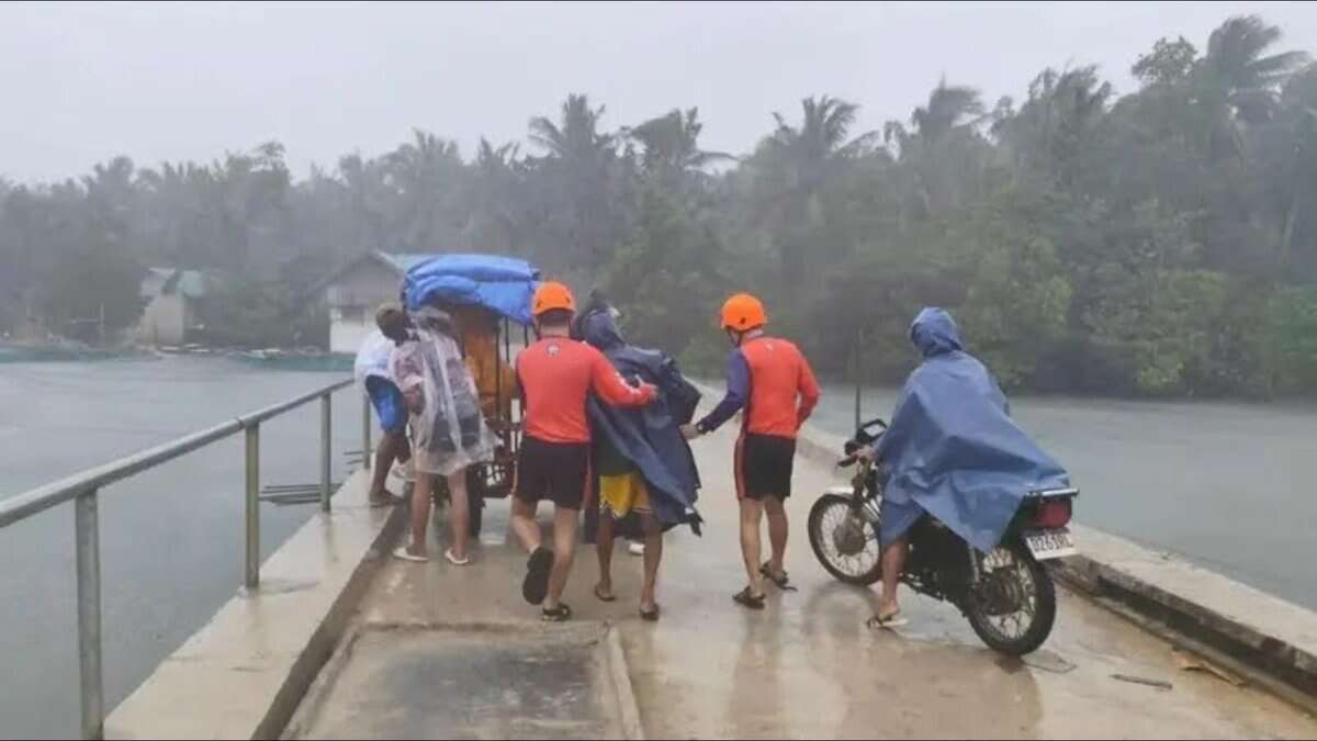 Philippine Coast Guard personnel assist residents during evacuations in heavy rain in Quezon province ahead of Super Typhoon Fung-wong.