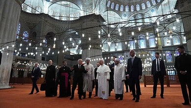 Pope Leo XIV tours the interior of Istanbul’s Sultan Ahmed Mosque with religious officials.