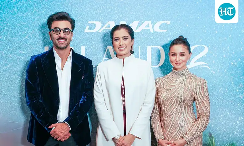 Three individuals pose for a photo at the launch event of DAMAC Islands 2 in Dubai.